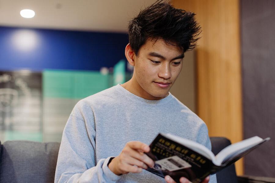 历史 student reads a book in the dorms.